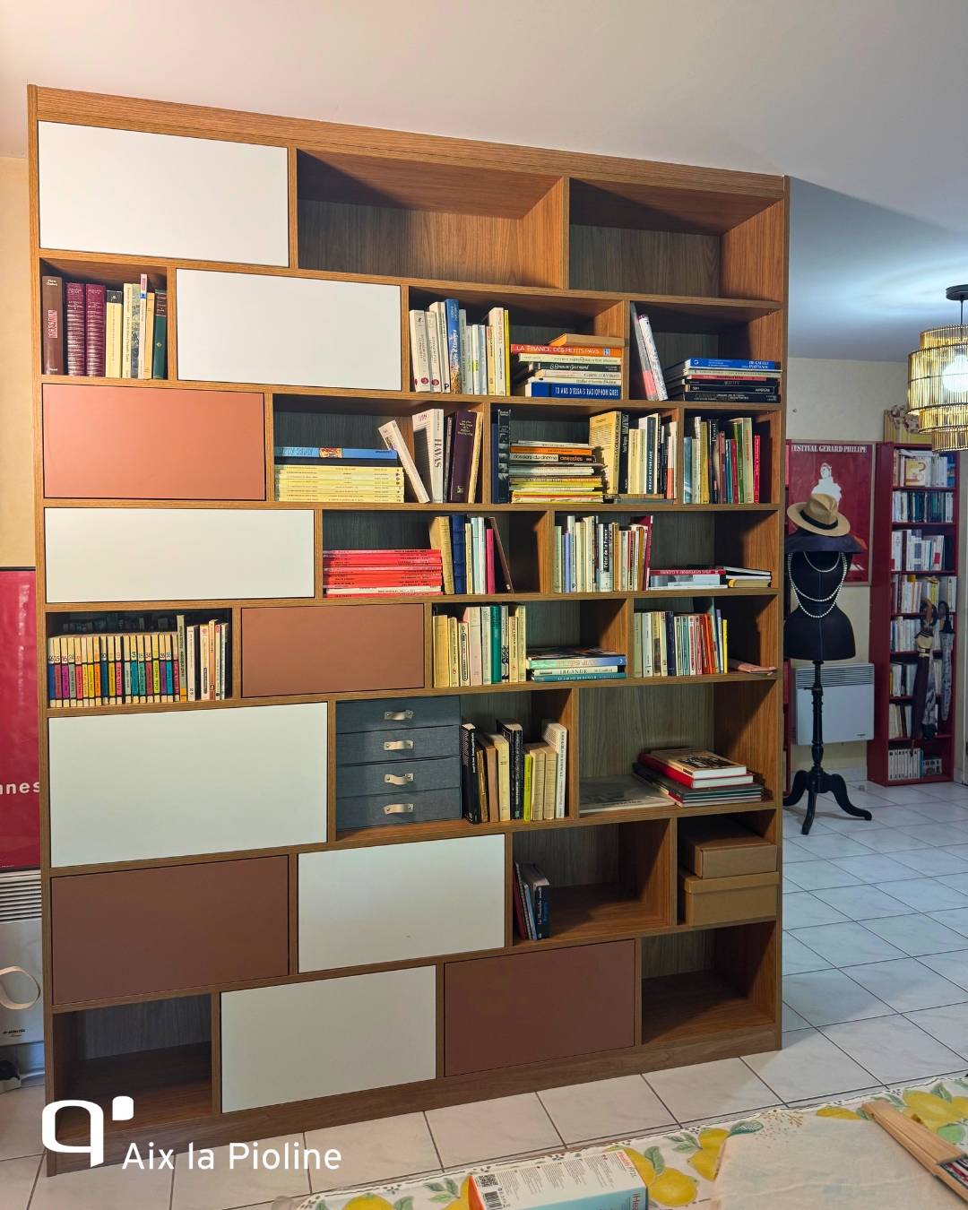 Bibliothèque sur mesure avec structure graphique bois clair et niches ouvertes à Aix en Provence