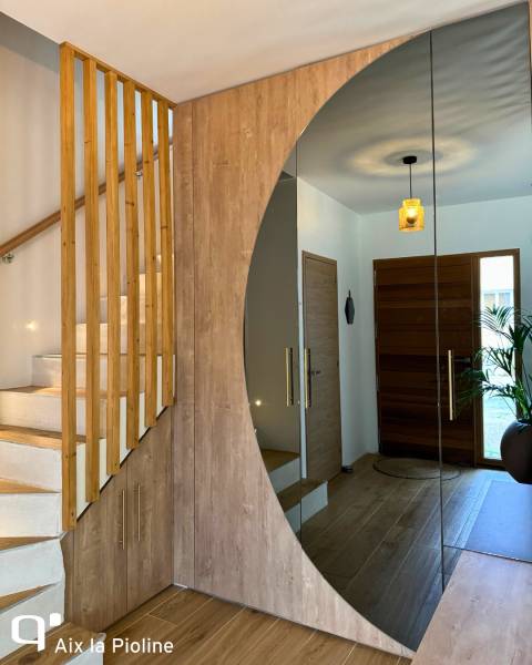 Une entrée sur mesure avec claustra en bois, miroir arrondi et rangement discrets lumineux à Peynier