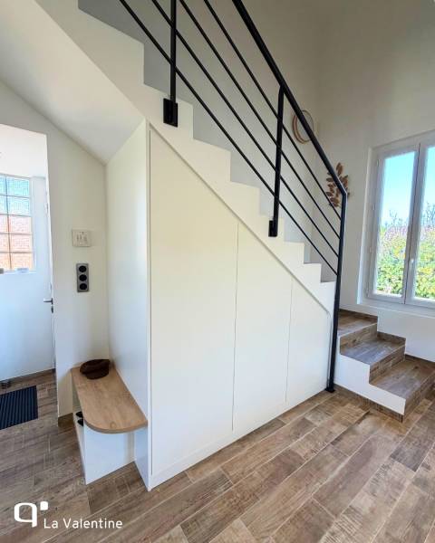 Meuble sous-escaliers sur mesure conçu pour s'intégrer discrètement à l'entrée avec banquette à Marseille 12eme