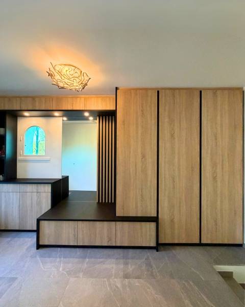 Entrée sur mesure bois et noir mat avec banquette intégrée et claustra verticales à Aix en Provence